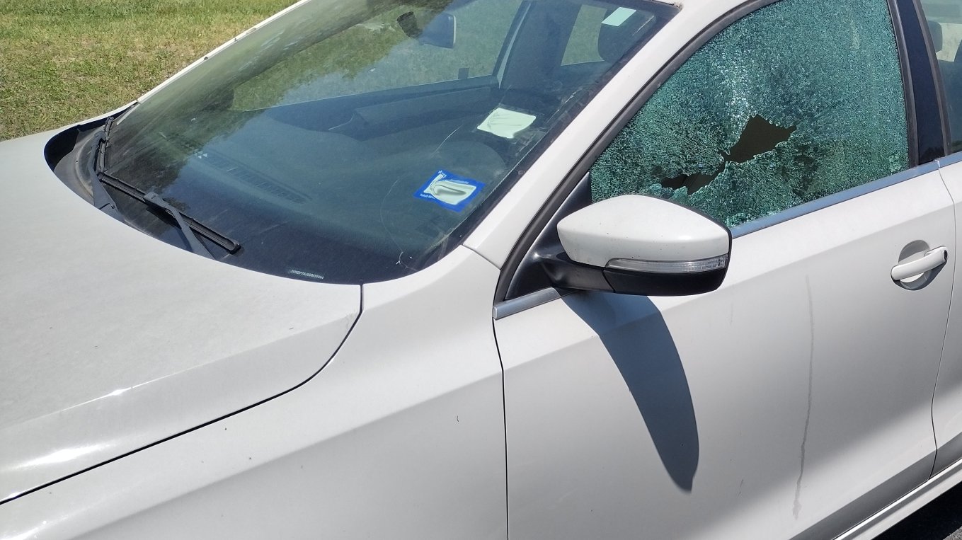 Shattered driver side window on a silver sedan before replacement